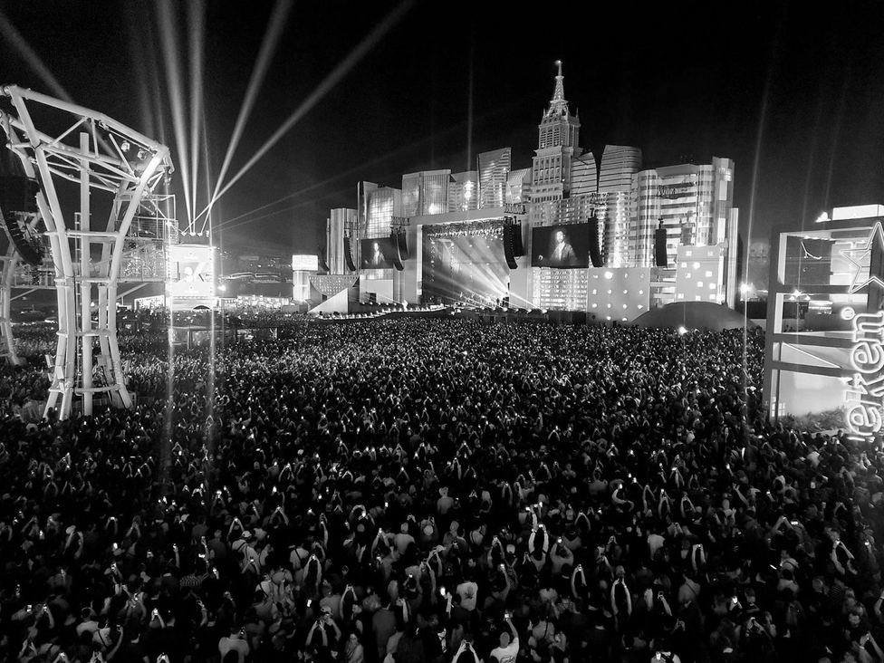 Público em show ao vivo sob luzes de palco